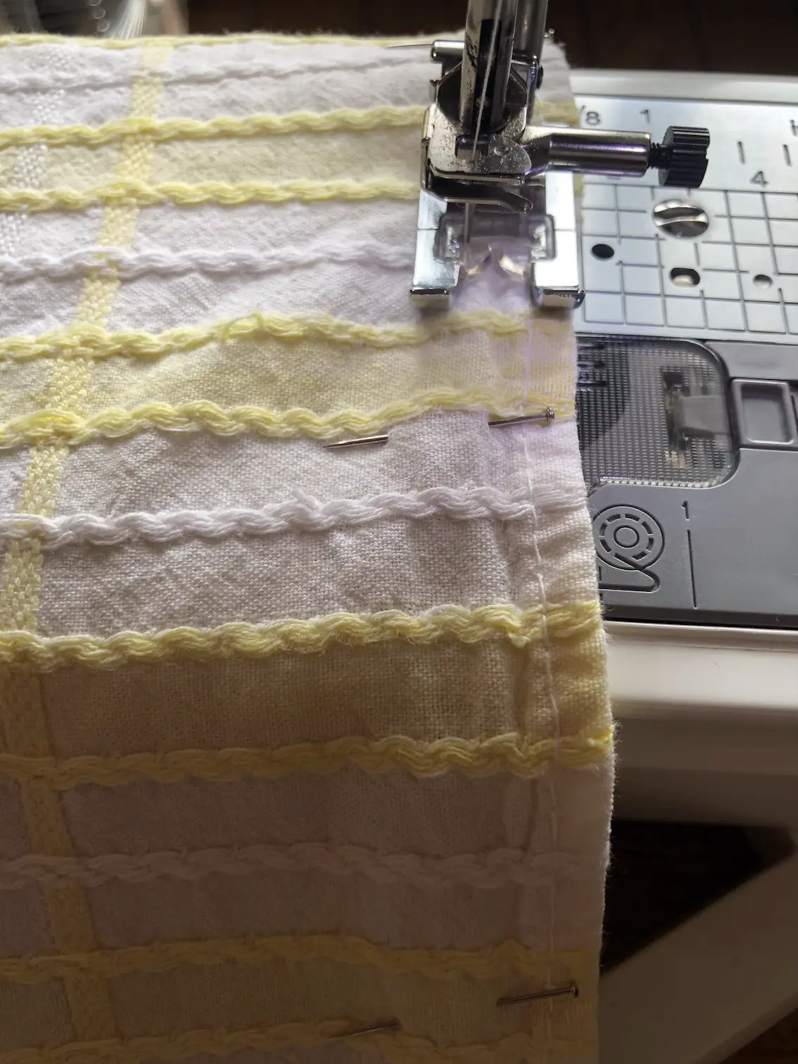 machine sewing a yellow and white checked tablecloth