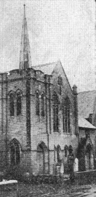 Grainy black and white picture of a church with a spire